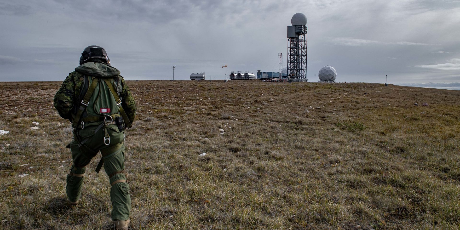 Corporal Muise from 408 Tactical Helicopter Squadron, Canadian Forces Base Edmonton, surveys a North Warning System RADAR tower in Cambridge Bay, Nunavut during Operation NANOOK, August 16, 2019. CAF photograph by Aviator Melissa Gloude PA08-2019-0004-007