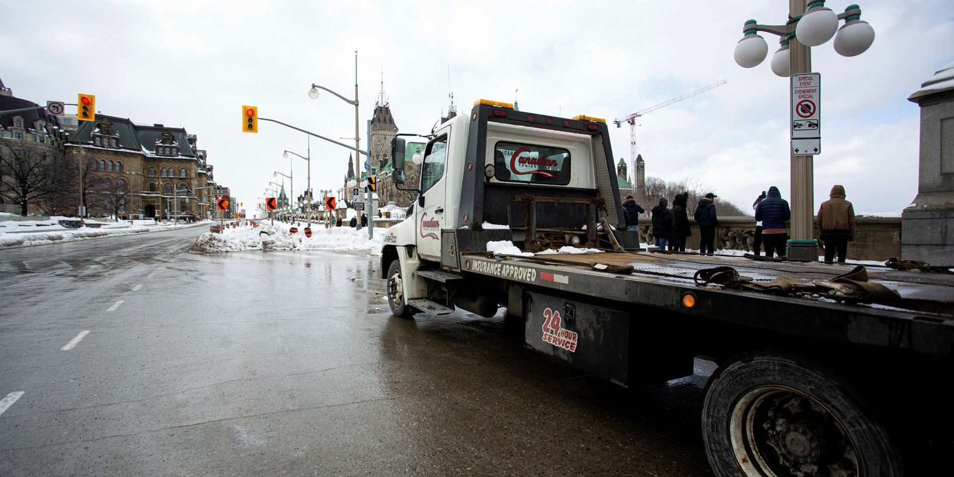 A flatbed tow truck sits parked within view of Parliament Hill on Jan. 28, 2023. Ottawa Bylaw Services said it issued 244 parking tickets and towed 25 vehicles tied to the event over the weekend. The Hill Times photograph by Andrew Meade
