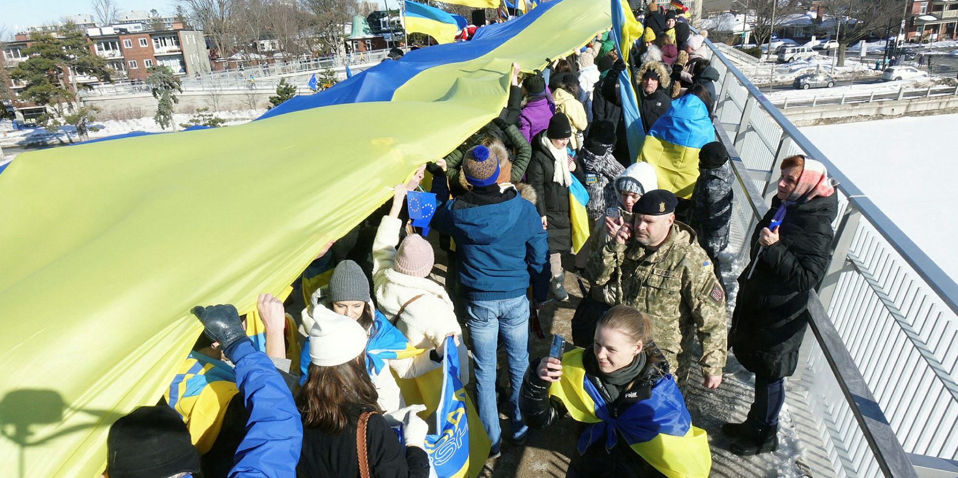 Attendees stretch out the massive Ukrainian flag.