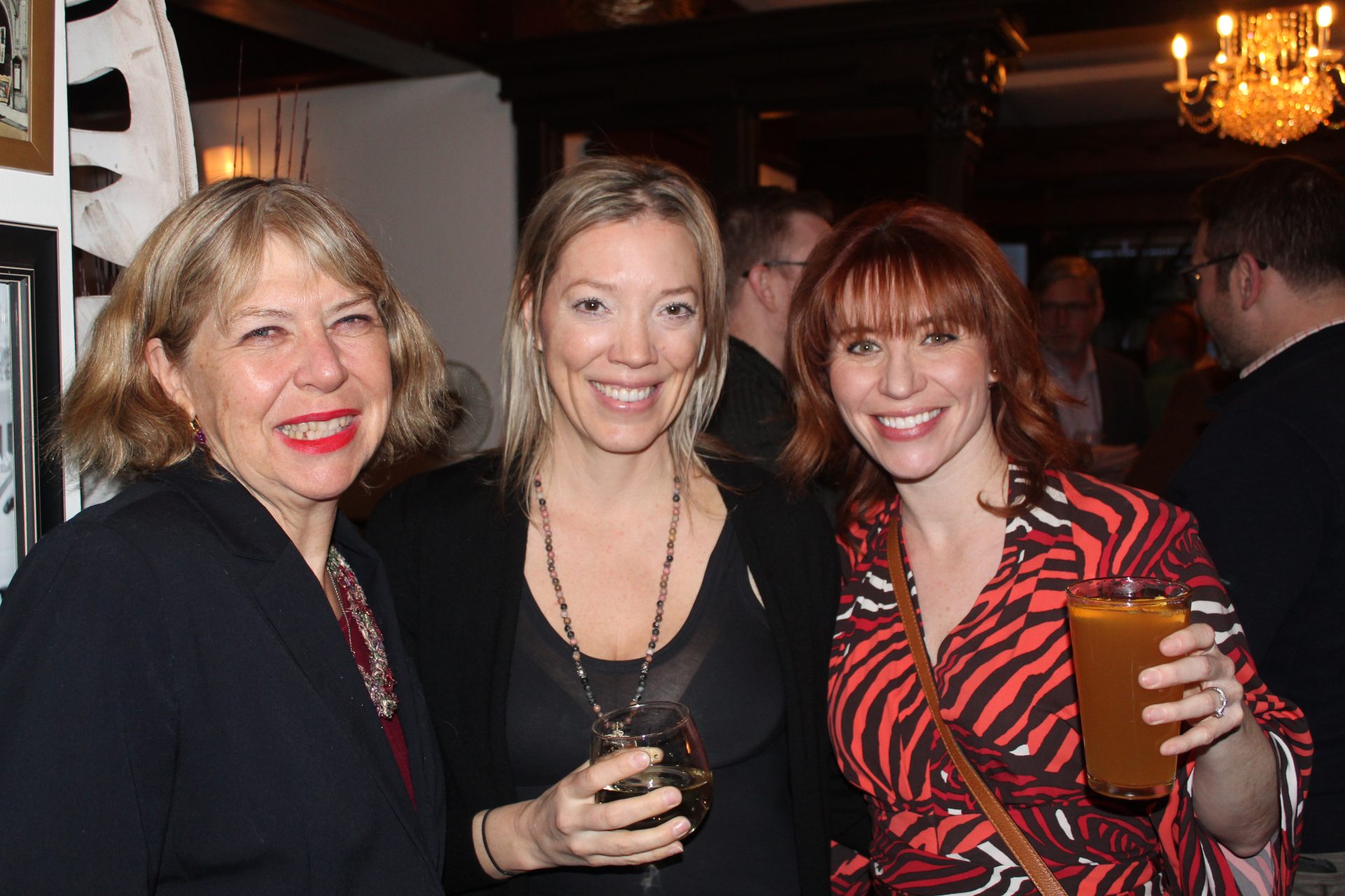 Ottawa City Councillor Theresa Kavanagh, left; and Shirlee Engle, right, public affairs counsellor Compass Rose; pose for a photo with  NDP's official bartender Julie McCarthy's at her surprise going away party on March 7, at Mozaik Street Foodery above Mulligans Golf Bar.