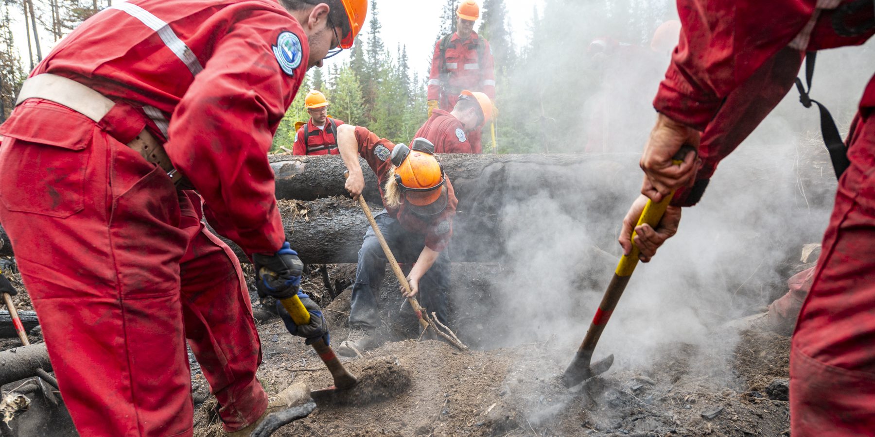 Members of 1st Regiment, Royal Canadian Horse Artillery, use axes to break up ground to help the BC Wildfire Service in suppressing fire hot spots outside Topley, B.C. in August 2023.