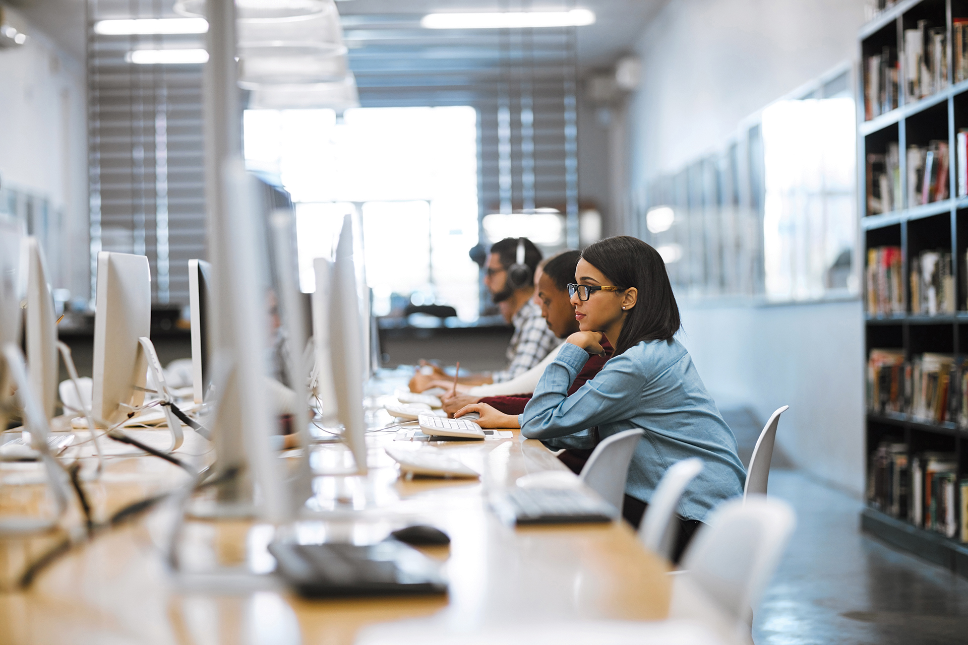Shot of a group of university students working on computers in the library at campus