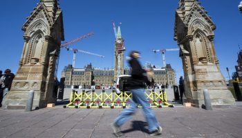 A person walks past the Queen’s Gate on  April 23, 2025. Centre Block. The Hill Times photograph by Andrew Meade