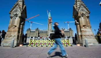 A person walks past the Queen’s Gate on April 23, 2025. The Hill Times photograph by Andrew Meade