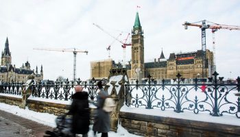 A person walks along Wellington Street past Centre Block on Jan. 13, 2026. The Hill Times photograph by Andrew Meade