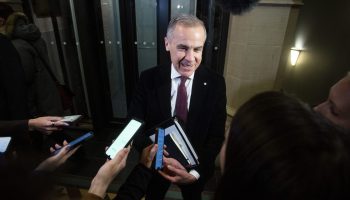 Prime Minister Mark Carney speaks with reporters before the Liberal party caucus meeting in West Block  on Dec. 10, 2025. The Hill Times photograph by Andrew Meade