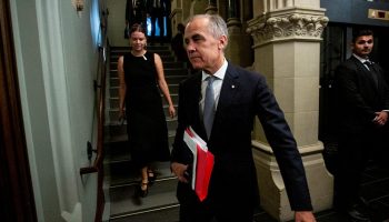 Prime Minister Mark Carney arrives for the Liberal party caucus meeting in West Block  on Sept. 17, 2025. (Woman coming down stairs is Audrey Champoux.) The Hill Times photograph by Andrew Meade