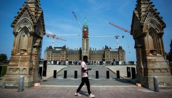 A person walks past Centre Block on June 4, 2025. The Hill Times photograph by Andrew Meade
