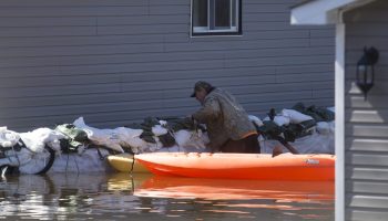 A home owner shores up sandbags around a property at Constance Bay  on Apr. 30, 2019. Residents have battled record water levels along the Ottawa River Valley resulting in unprecedented flood damage. Andrew Meade