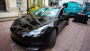 A Tesla EV is plugged into a CAFU En-Charge mobile electric vehicle charging station on Sparks Street as part of a showcase of the Canadian Zero-Emissions Vehicle supply chain on Sept. 27, 2023. Andrew Meade