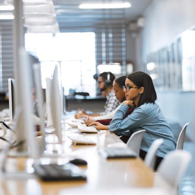 Shot of a group of university students working on computers in the library at campus