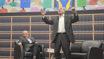 Former Liberal MP Sergio Marchi, right, jumps up while telling a story about his time in politics during an interview with journalist Andrew Cohen in Ottawa on Nov. 18, 2025. The Hill Times photograph by Tessie Sanci