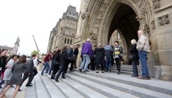 Visitors and staff file back in to Centre Block after an alarm triggered an evacuation Oct. 11, 2017. Ottawa Fire Services responded to the call but operations in the building resumed shortly after their arrival.