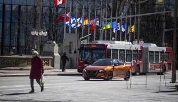 The Canadian and provincial flags remain at half mast in downtown Ottawa on March 11, 2024, to honour the death of former prime minister Brian Mulroney. The Hill Times photographs by Andrew Meade
